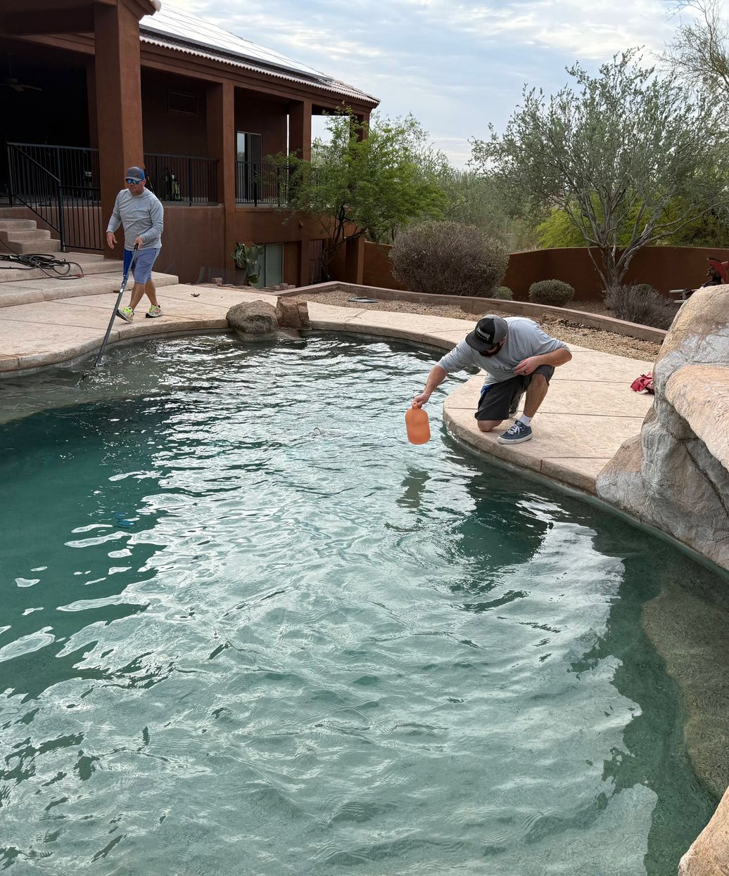 pool technicians adding acid to balance pool chemistry