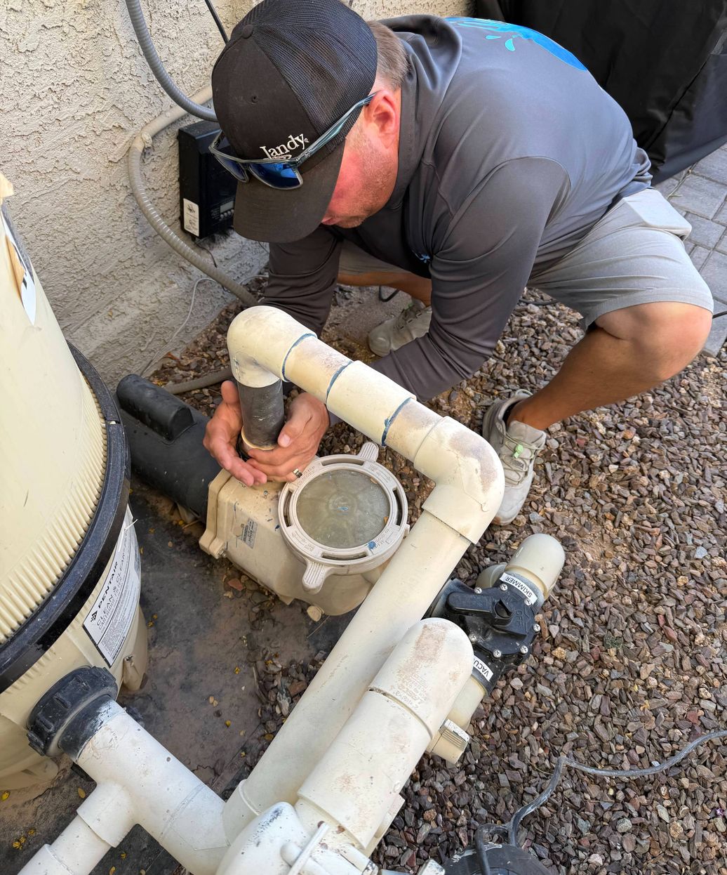 pool technician inspecting equipment for leak detection and repair