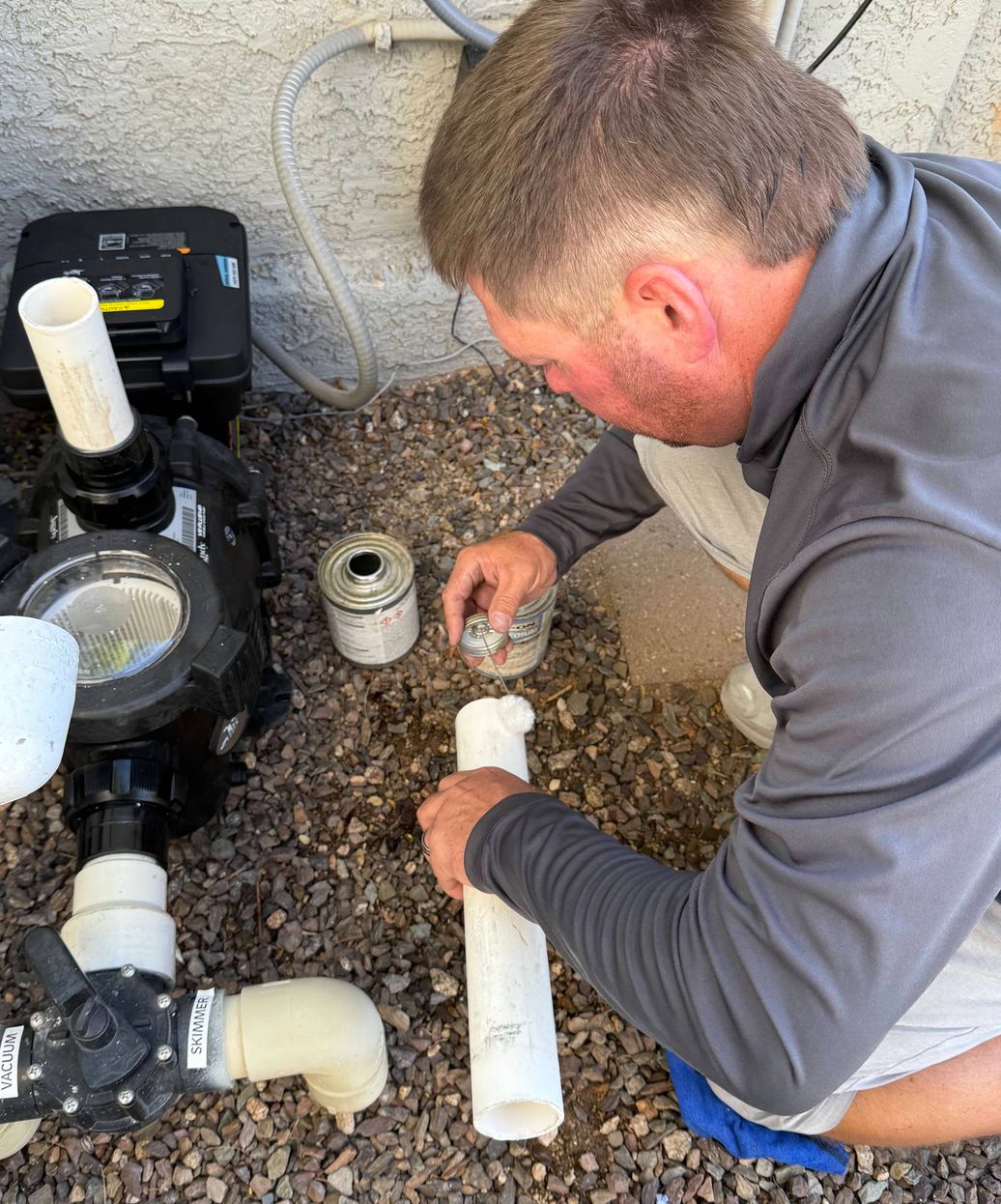 pool technician repairing pool pump and priming system